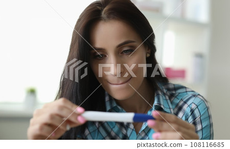 Woman squeezing lips looks test determine pregnancy 108116685