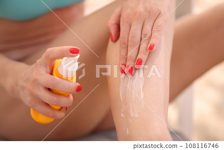 Woman applying sunscreen to her feet closeup Woman applying sunscreen to her feet closeup 108116746