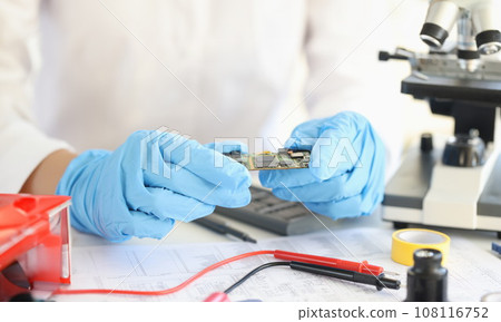 Scientists holding microchip in rubber gloves in laboratory closeup Scientists holding microchip in rubber gloves in laboratory closeup 108116752