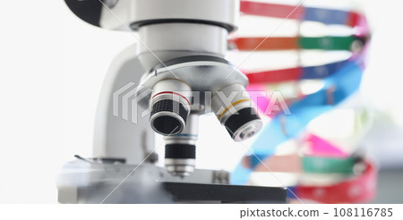 Microscope standing near multicolored model of dna chain in lab 108116785
