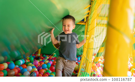 Happy smiling toddler boy playing in children's playroom. Active lifestyle, childhood. Selective focus 108116787