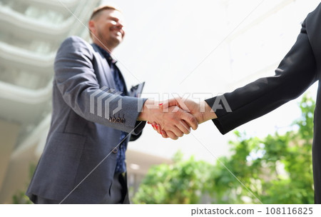 Business man and woman in suits shaking hands closeup 108116825