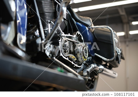Open chromed motorcycle motor with chain on bench in garage Open chromed motorcycle motor with chain on bench in garage 108117101