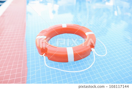 Orange plastic lifebuoy floating in pool closeup 108117144