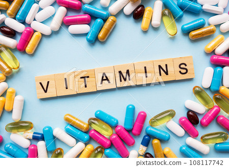 Health and medicine concept. Different colorful pills for different symptoms, in the middle - the inscription vitamins in wooden letters. Health and medicine concept. Different colorful pills for different symptoms, in the middle - the inscription vitamins in wooden letters. 108117742
