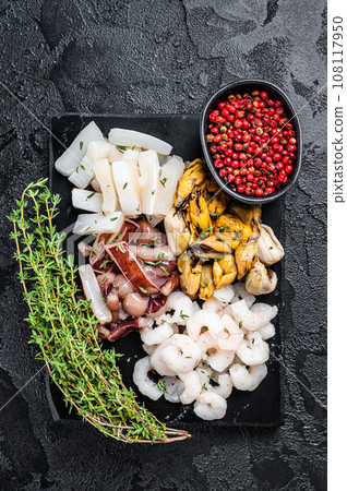 Seafood assorted platter, mix of mussels, clams, squid, octopus, shrimps and prawn. Black background. Top view 108117950