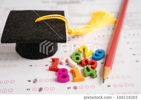 Graduation gap hat and pencil on answer sheet paper, Education study testing learning teach concept. 108118265