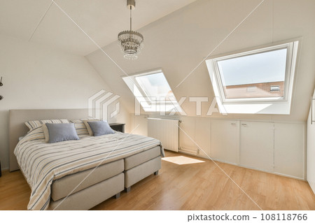 a bed in a room with skylights on the roof and wood flooring around it, as well as possible a bed in a room with skylights on the roof and wood flooring around it, as well as possible 108118766