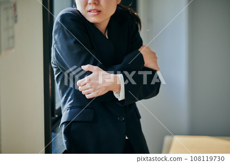 一個冷漠的年輕女上班族在窗邊瑟瑟發抖 108119730