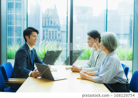 一個穿西裝的男人向一對中年夫妻解釋 108120754