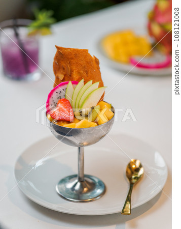 Tropical Paradise sorbet with grapefruit, mango, passion fruit decorated with fresh fruit and crispy tuile cookies. Tropical ice cream in metal sundae bowl. Summer ice cream concept Tropical Paradise sorbet with grapefruit, mango, passion fruit decorated with fresh fruit and crispy tuile cookies. Tropical ice cream in metal sundae bowl. Summer ice cream concept 108121008