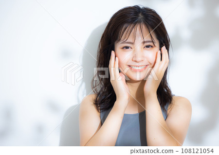 A woman in the sunlight filtering through the trees 108121054