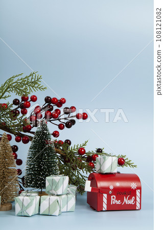 Composition with many gifts, a branch of holly with its red berries, a santa claus mailbox and christmas tree Composition with many gifts, a branch of holly with its red berries, a santa claus mailbox and christmas tree 108121082