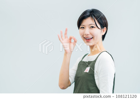 Part-time woman working at a restaurant taking an OK pose, white background Part-time woman working at a restaurant taking an OK pose, white background 108121120