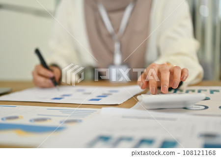 Female accountant checking marketing research results or statistics data at office desk 108121168