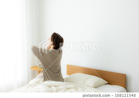 A woman sitting on a bed A woman sitting on a bed 108121548