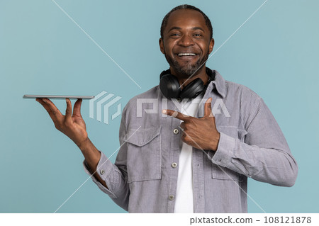 Smart guy pointing at device showing tablet design. Smart guy pointing at device showing tablet design. 108121878