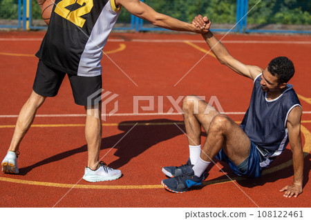 Basketball players on basketball court after playing intense match. 108122461