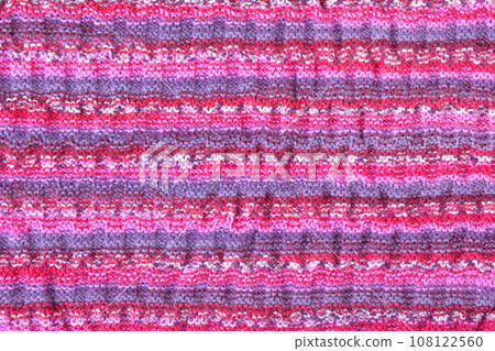 Abstract knitted colorful background. Wave pattern of pink, blue, yellow, purple knitting threads. Close-up of a knitted blanket. Copy space 108122560