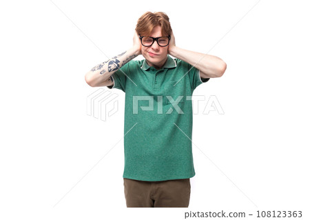 a young red-haired man dressed in a green T-shirt is trying to concentrate on his thoughts a young red-haired man dressed in a green T-shirt is trying to concentrate on his thoughts 108123363