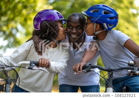 African american family having good time in a park and riding bikes African american family having good time in a park and riding bikes 108123521