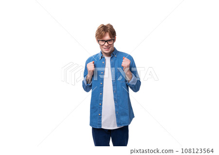 young handsome caucasian man with short red hair dressed in a blue shirt on a white background with 108123564