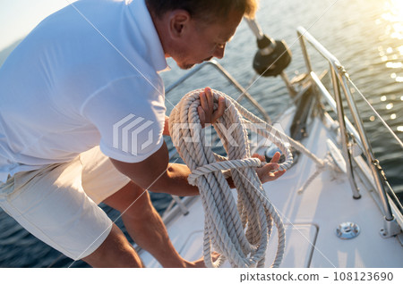 Man on a yacht getting ready for traveling Man on a yacht getting ready for traveling 108123690