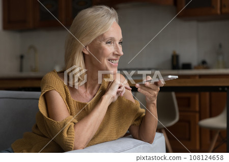 Cheerful happy mature woman making cellphone call, talking on speaker 108124658