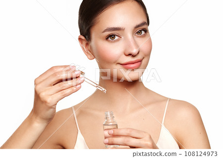 Young beautiful woman applying face serum 108124973