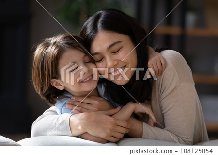 Close up smiling Asian mother and son hugging Close up smiling Asian mother and son hugging 108125054