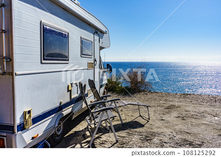 Rv camper camping on sea shore, Spain. 108125292