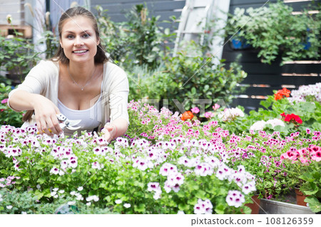 Nice european girl looking at flowers in shop 108126359