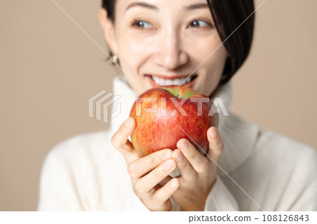 Young woman holding an apple (apple focus) Young woman holding an apple (apple focus) 108126843