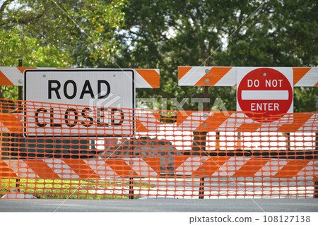 Road closed at construction site with protective fence barrier Road closed at construction site with protective fence barrier 108127138