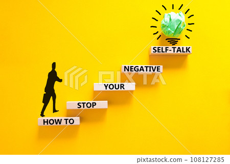 Stop negative self-talk symbol. Concept words How to stop your negative self-talk on wooden block. Psychologist icon. Beautiful yellow background. Psychological negative self-talk concept. Copy space 108127285
