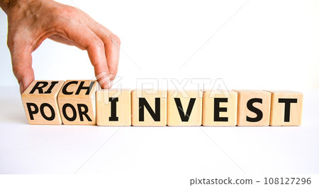Rich or poor invest symbol. Businessman turns cubes and changes words poor invest to rich invest. Beautiful white table, white background, copy space. Business and rich or poor invest concept. 108127296