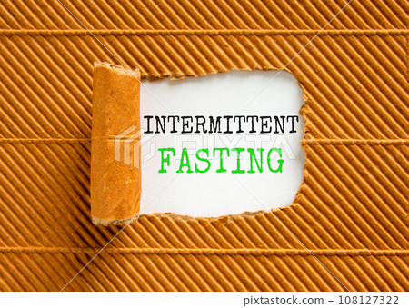 Intermittent fasting symbol. Concept words Intermittent fasting on beautiful white paper. Beautiful brown background. Healthy lifestyle intermittent fasting concept. Copy space. 108127322
