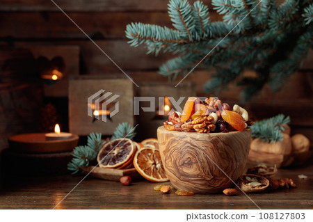 Dried fruits and assorted nuts on an old wooden table. 108127803