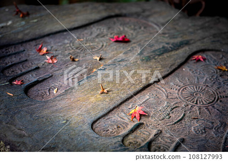 Autumn at Honen-in Temple, colorful fallen maple leaves falling on the Buddha foot stone 108127993