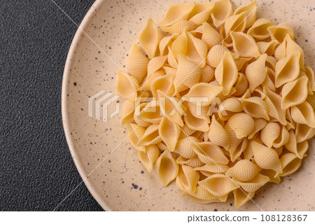 Raw Italian pasta conchiglie from durum wheat with vegetables, salt and spices 108128367