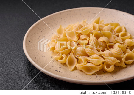 Raw Italian pasta conchiglie from durum wheat with vegetables, salt and spices 108128368