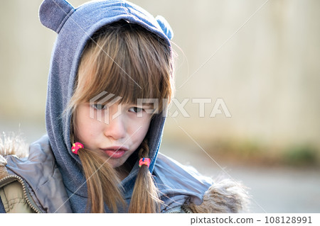 Portrait of happy child girl in warm clothes in autumn outdoors. 108128991