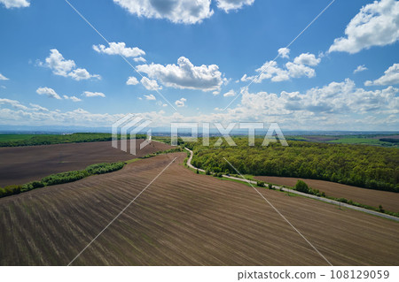 Plowed bare agricultural field with cultivated fertile soil prepared for seeding crops in spring season 108129059