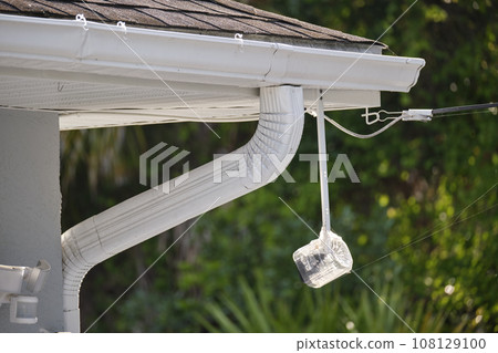 Motion sensor with light detector mounted on exterior wall of private house as part of security system Motion sensor with light detector mounted on exterior wall of private house as part of security system 108129100