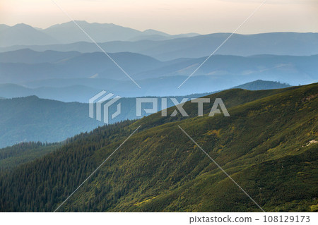 Landscape view of green majestic Carpathian mountains covered with light mist in dawn. Landscape view of green majestic Carpathian mountains covered with light mist in dawn. 108129173
