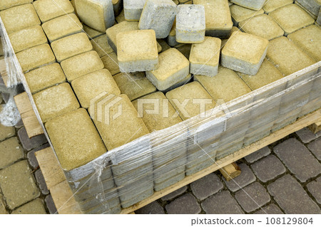 Installation of stone paving slabs in a yard. Installation of stone paving slabs in a yard. 108129804