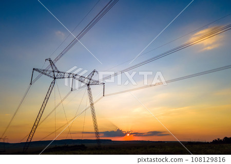 High voltage towers with electric power lines at sunset. 108129816