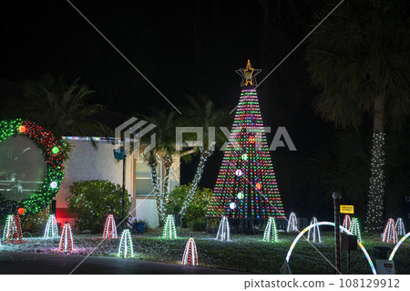 Front yard with brightly illuminated christmas decorations. Outside decor of florida family home for winter holidays 108129912