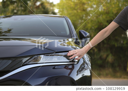 Female driver hands checking headlight of her new car. Purchase of vehicle concept 108129919