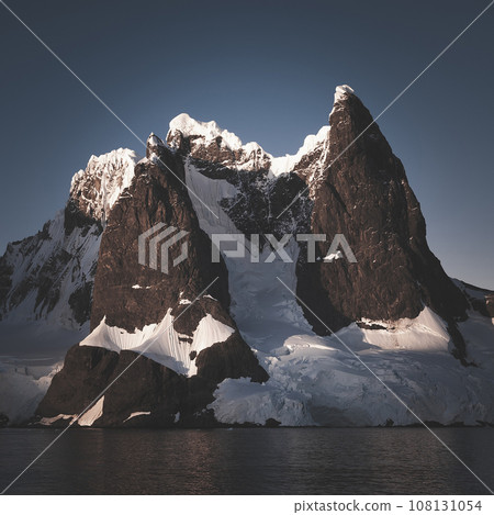 Lemaire strait coastal landscape, mountains and icebergs, Antarctic Peninsula, Antartica. 108131054